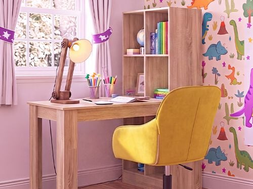 Habitaci&oacute;n de estudio infantil luminosa con escritorio de madera, silla amarilla ergon&oacute;mica, l&aacute;mpara de escritorio, estanter&iacute;a de almacenaje y papel pintado de dinosaurios, ideal para crear en casa un espacio de aprendizaje organizado y c&oacute;modo.
