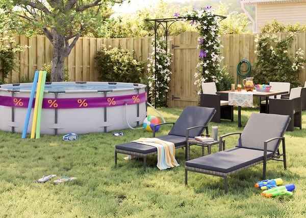 Jard&iacute;n trasero soleado con piscina elevada, churros de piscina, gafas de nataci&oacute;n, pelota de playa y chanclas sobre el c&eacute;sped. Dos tumbonas negras de metal con cojines grises se sit&uacute;an junto a una peque&ntilde;a mesa auxiliar, mientras un comedor de exterior con sillas oscuras de rat&aacute;n queda junto a una p&eacute;rgola con flores, una valla de madera y plantas de jard&iacute;n.