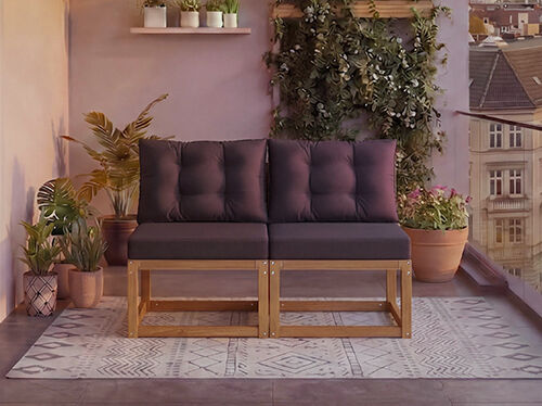 Sof&aacute; modular de madera de dos plazas con cojines gris oscuro en un balc&oacute;n rodeado de plantas en maceta y vistas a la ciudad al fondo