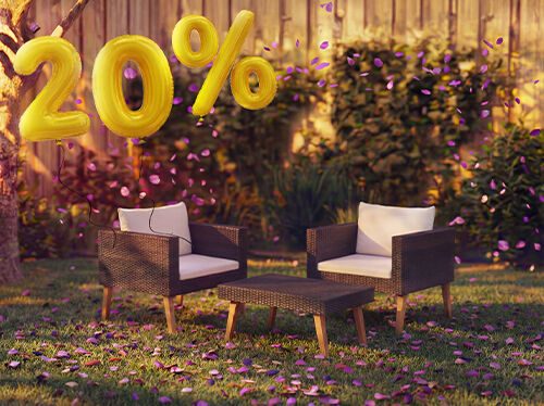 Sillones lounge de rat&aacute;n para exterior con cojines y una peque&ntilde;a mesa en un entorno de jard&iacute;n, decorados con confeti rosa y globos dorados con &laquo;20 % de descuento&raquo;, que destacan ofertas de temporada en muebles lounge de jard&iacute;n.
