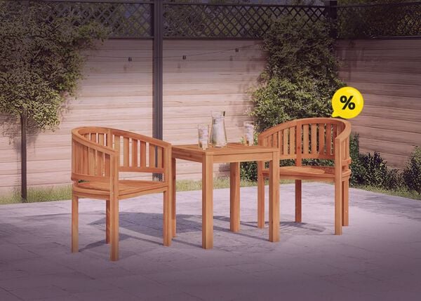 Dos sillas de madera y una mesa en un patio rodeado de vegetaci&oacute;n, con iconos de descuento amarillos. Haz clic para ver los productos en oferta. 
